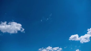 Tüylü beyaz bulutları yakalar ve derin mavi gökyüzünün uçsuz bucaksız genişliğinde sürüklenir ve evrimleşir. Değişen hava modelleri ve atmosferik hareketin dinamik ve dinamik çekimi.