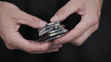 Bir kişi bir avuç eski, modası geçmiş cep telefonu bataryalarını inceliyor. Bu yakın çekim elektronik atıkları, uygun şekilde imha edilmesini ve tehlikeli madde ve bileşenlerin geri dönüşümünü vurguluyor..