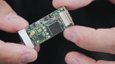 Küçük bir entegre devre kartının el ele tutuşup incelenmesi. Çip sensörlü bu mikro elektronik modül modern kompakt teknolojisi ve gelişmiş donanım için bir bileşendir..