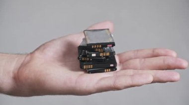 Elektronik hurda ve kaynak kurtarma kavramını gösteren, eski cep telefonlarından alınmış ve kullanılmış lityum iyon pilleri sergilenen bir elin yakın çekimi.