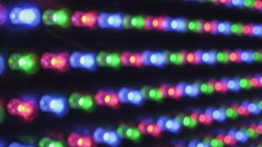 Uysal odak makro görüntüsü yatay RGB LED ışık şeritleri, bireysel kırmızı, yeşil ve mavi diyotlar yanıp sönüyor ve renk desenleri hızla değişiyor, soyut, canlı bir teknoloji görüntüsü yaratıyor.