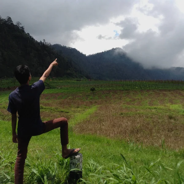 在爪哇中部的沙兰甘 一个摆姿势的男人拿着稻田 高山和云彩指着天空 — 图库照片