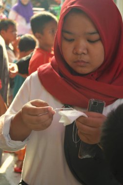 Jakarta, Endonezya - 08: 27 2016: Bağımsızlık Günü 'nü kutlarken türbanlı bir kadının gazete açması