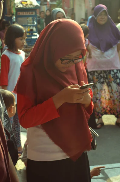 ジャカルタ インドネシア 8月27日2016年 赤いヒジャーブを着た女性がインドネシアの72回目の独立記念日を祝いながら携帯電話を演奏する — ストック写真