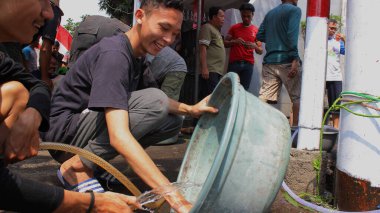 Jakarta, Endonezya - 08 11 2019: Kurban Bayramı 'nda kova yıkayan erkeklerin mutlu yüz ifadeleri