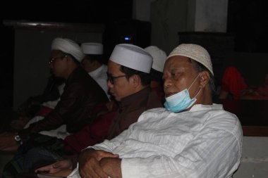 Bogor, Endonezya - 03: 20 2021: Müslüman insanlar, dindar bir liderden ders dinlerken rahat bir şekilde oturuyorlar