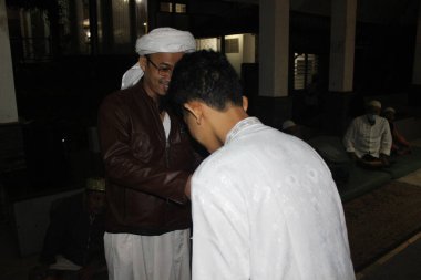 Bogor, Endonezya - 03: 20 2021: Çocuk ve dini lider hediye vermek için el sıkışıyor