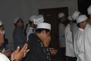 Bogor, Endonezya - 03: 20 2021: Dua ederken yüzünü örten Müslüman gençlik