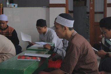 Jakarta, Endonezya - 05 08 2021: Camide Ramadhan yatılı okuluna giderken kitap okuyan İslami yatılı okul öğrencileri