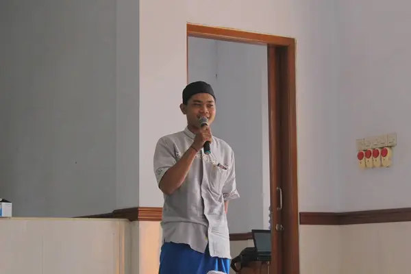 Jakarta, Endonezya - 05 08 2021: Camide bir Ramadhan yatılı okuluna giderken elinde mikrofon tutan Müslüman bir çocuğun ifadesi