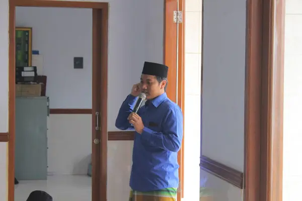 Jakarta, Endonezya - 05 08 2021: Camide bir Ramadhan yatılı okuluna giderken elinde mikrofon tutan Müslüman bir çocuğun ifadesi