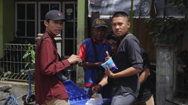 Purwakarta, Endonezya 12.2021: yol kenarında atıştırmalık yiyen bir adam
