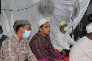 Jakarta, Endonezya - 01 28 2022: Peygamber Muhammed 'in doğum gününü kutlarken tıbbi maske takan adam
