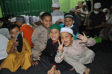 Jakarta, Endonezya - 01 28 2022: Muhammed peygamberin doğum günü kutlamalarına katılan çocukların birlikte fotoğraf çektikleri mutlu yüz ifadeleri