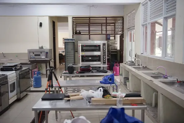 Ev eşyalarıyla dolu dağınık bir masası olan mutfak odası.
