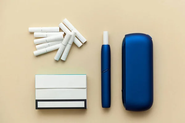电子蓝色Iqos香烟 盒子上有香烟的米色背景 — 图库照片