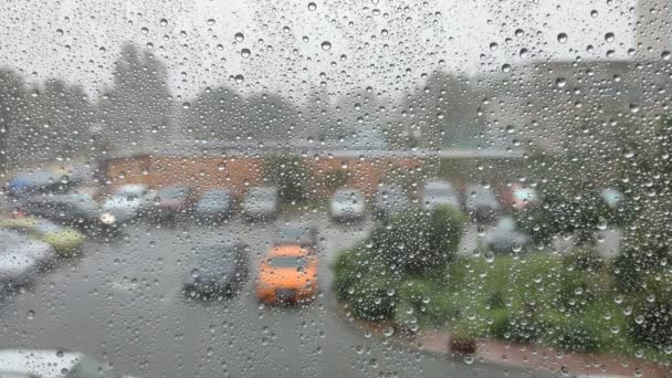 Bulutlu Bir Günde Penceredeki Yağmur Damlalarının Manzarası Otopark Manzaralı — Stok video