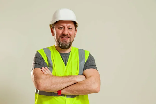 Stock image A man worker in a vest and a white construction helmet in different poses stands on a white background