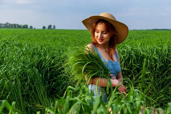 Egy Gyönyörű Lány Farmerruhában Kalapban Egy Zöld Mezőn Egy Csokor — Stock Fotó