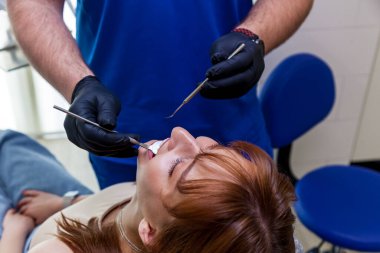 Doktor dişçi, tedavi öncesi dişlerini muayene eder.