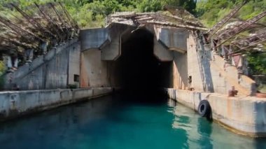 Karadağ kıyısı yakınlarında terk edilmiş, ürkütücü bir deniz altı tüneli. Eski altyapının kalıntılarıyla çevrili bu beton tünelin girişi, bölgenin askeri tarihini yansıtan derin turkuaz sulara açılıyor. 