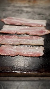 Çiğ domuz pastırmasının ızgarada altın gibi çıtır çıtır mükemmelliğe dönüşmesini izleyin. Kahvaltı, hamburger ya da aperatifler için mükemmel. Bu pastırma şeritleri dayanılmaz.