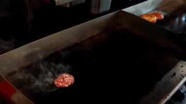 Eldiven giyen bir şef kızartma yüzeyinde et ve soğan kızartmak için pres kullanır. Mutfak projeleri, restoran reklamları ve yemek blogcuları için mükemmel bir video..