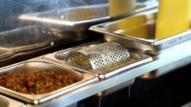 Eldiven giyen bir şef hamburger ekmeğine sos ve sebze ekler. Fast food restoranı için taze malzemeler kullanarak iştah açıcı pişirme işlemi..