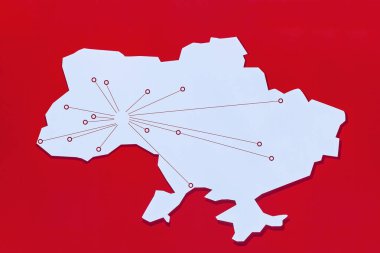 Ukrayna 'nın radyal bağlantı hatları ve düğümlerine sahip stilize edilmiş haritası, canlı kırmızı bir zemin üzerinde iletişimi, lojistik veya dijital altyapıyı sembolize eder.