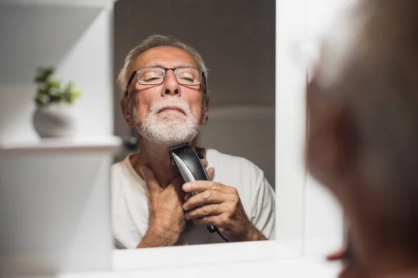 Homem Sênior Está Aparando Sua Barba Com Aparador Elétrico Banheiro — Fotografia de Stock