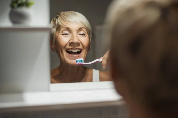 Reife Frau Putzt Ihre Zähne Badezimmer — Stockfoto