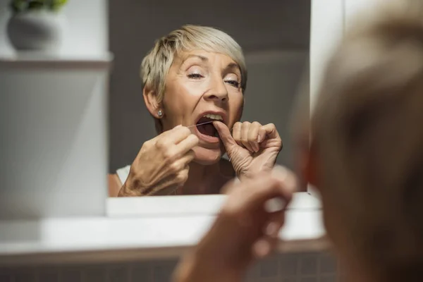 Reife Frau Benutzt Zahnseide Ihre Zähne Reinigen — Stockfoto