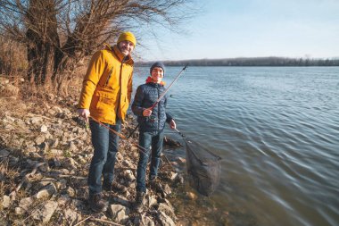 Father and son are ready for fishing on winter day. Freshwater fishing.