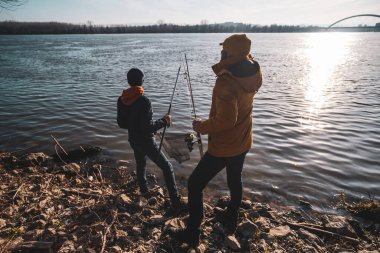 Father and son are ready for fishing on winter day. Freshwater fishing.