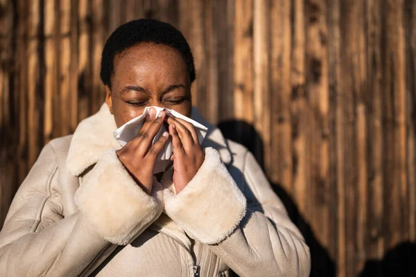 stock image Outdoor portrait of african-american woman. She is blowing her nose.