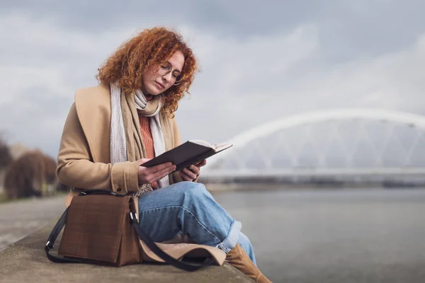 Καυκάσια Κοκκινομάλλα Γυναίκα Φακίδες Και Σγουρά Μαλλιά Χαλαρώνει Και Διαβάζει — Φωτογραφία Αρχείου