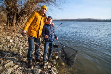 Father and son are ready for fishing on winter day. Freshwater fishing.