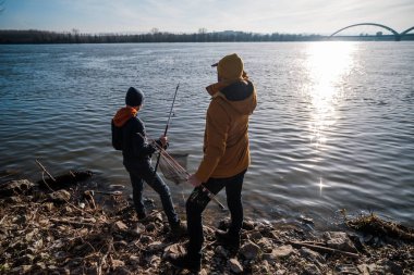 Father and son are ready for fishing on winter day. Freshwater fishing.