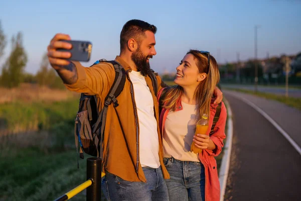 Glædeligt Smilende Par Nyder Solnedgang Tager Selfie - Stock-foto