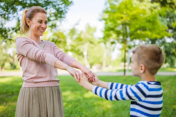 幸せな母親は公園で息子と遊んでいる 手を握っている — ストック写真
