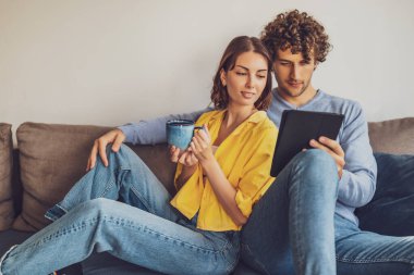 Evdeki mutlu genç çiftin portresi. Kanepede dinleniyorlar..