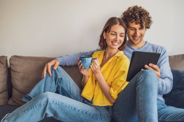 Evdeki mutlu genç çiftin portresi. Kanepede dinleniyorlar..