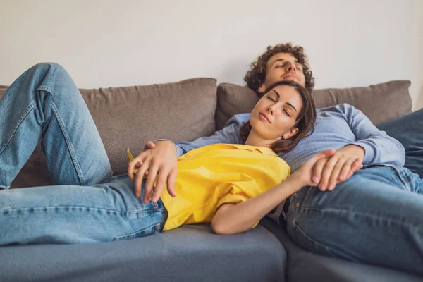 stock image Portrait of young happy couple at home. They are relaxing at sofa.