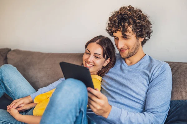 Evdeki mutlu genç çiftin portresi. Kanepede dinleniyorlar..