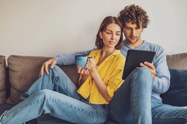 Evdeki mutlu genç çiftin portresi. Kanepede dinleniyorlar..