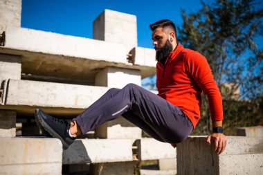 Genç adam dışarıda egzersiz yapıyor. Ters şınav çekiyor..