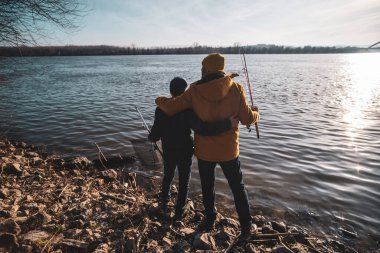 Father and son are ready for fishing on winter day. Freshwater fishing.
