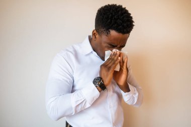 Alerjisi olan ve burnunu silen genç iş adamının portresi. Metnin ya da ilanın için resim üzerine boşluk kopyala.