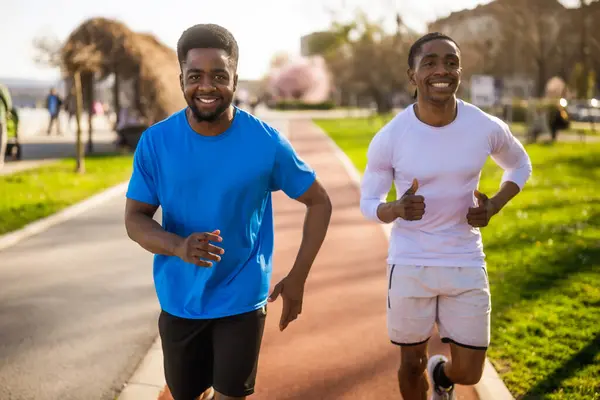 アフリカ系アメリカ人の2人の友人が街でジョギングをしている — ストック写真