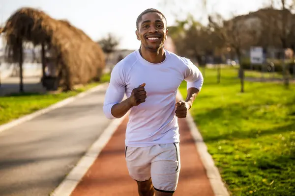 アフリカ系アメリカ人の若者が街でジョギングをしている — ストック写真